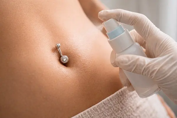 Zagojony piercing pępka z delikatną biżuterią po okresie prawidłowej pielęgnacji